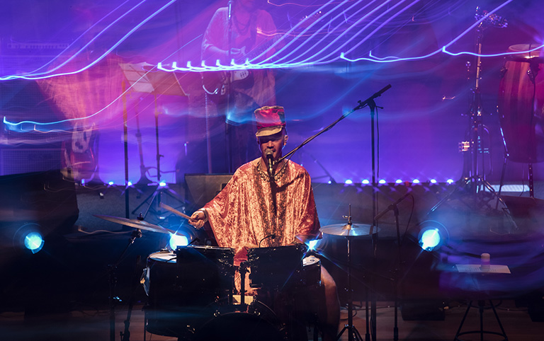 Fotografia colorida de Curumin e banda cantando Stevie Wonder no Sesc 24 de maio - por Diogo França