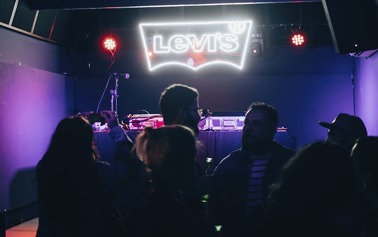 Fotografia colorida de um bar com letreiro LEVIS ao fundo por Breno da Matta 